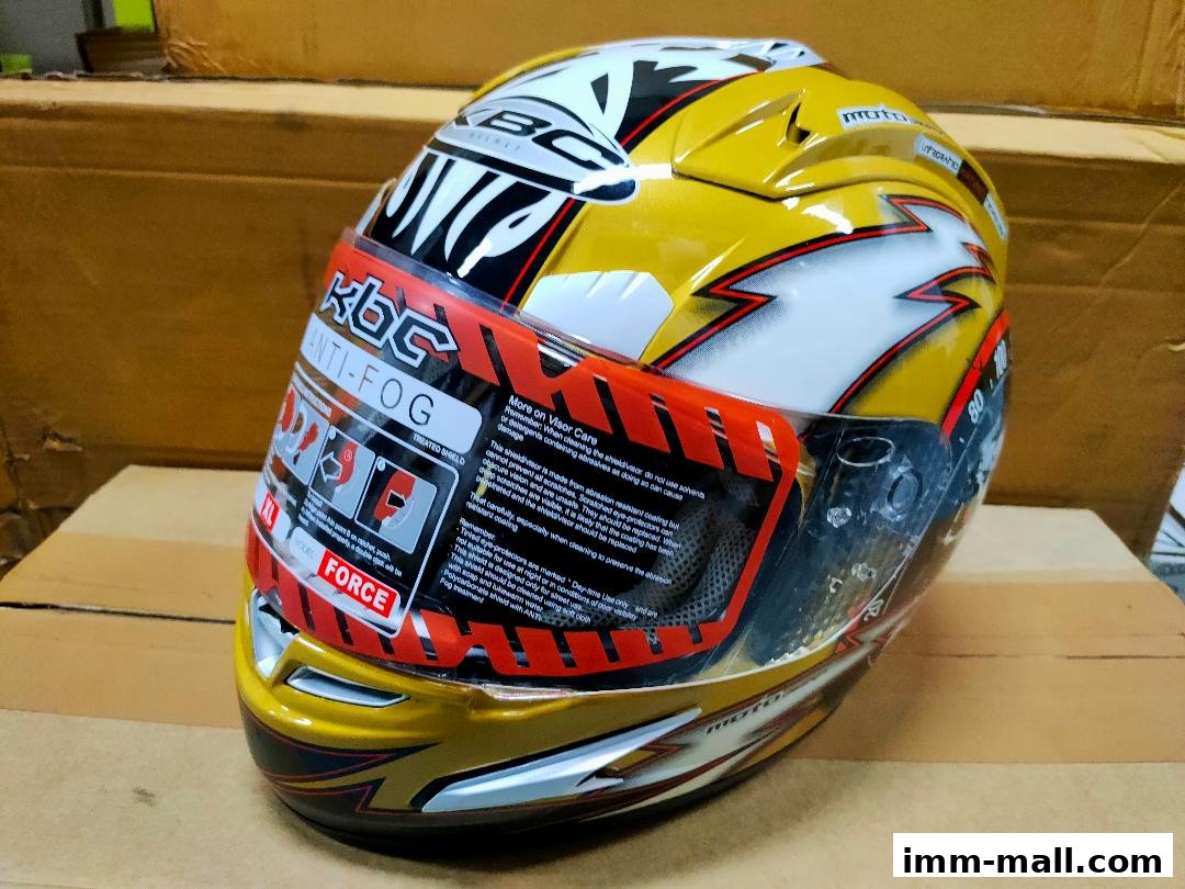 A yellow and white KBC anti-fog motorcycle helmet with racing graphics.