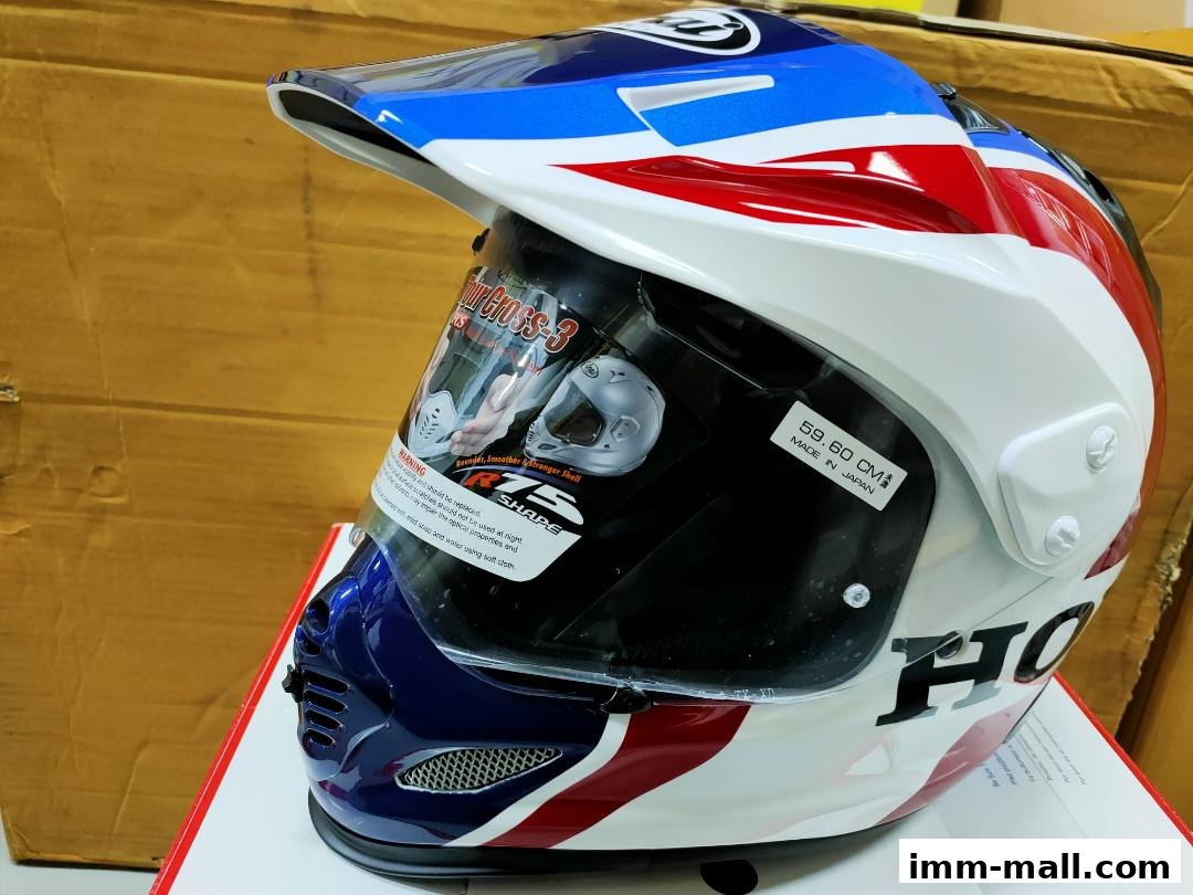 A close-up view of a white, blue, and red motorcycle helmet with a visor.