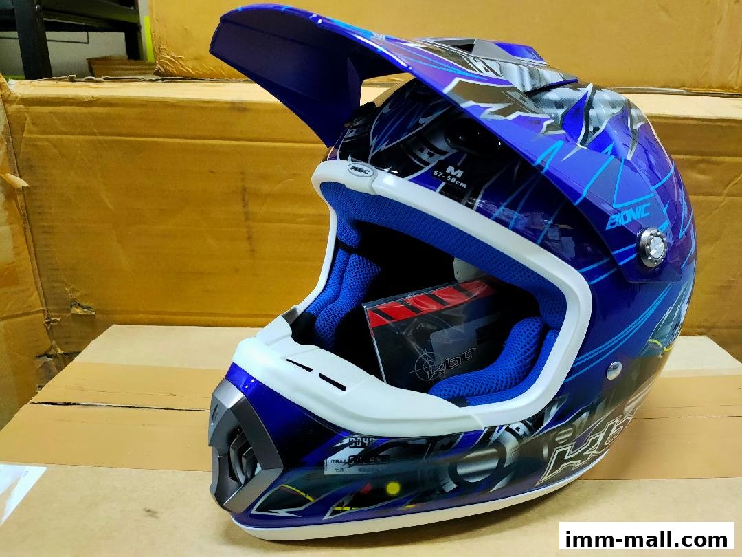 A blue and white motocross helmet with a graphic design, displayed on cardboard boxes.