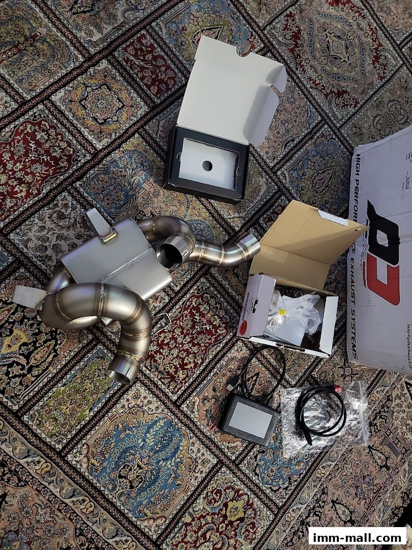 High-performance exhaust system components and control unit laid out on a patterned rug.