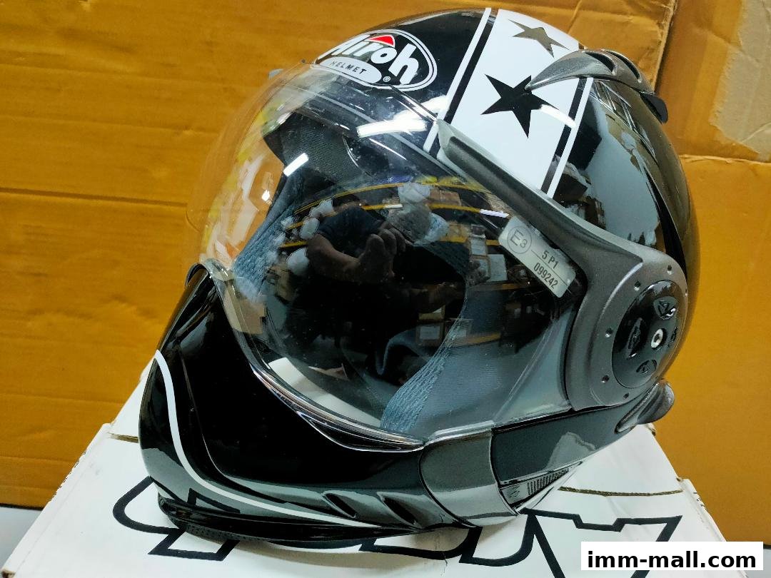 A black and white motorcycle helmet with a clear visor and star graphics.