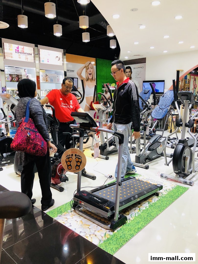 Customers are browsing fitness equipment in a well-lit store with various exercise machines.