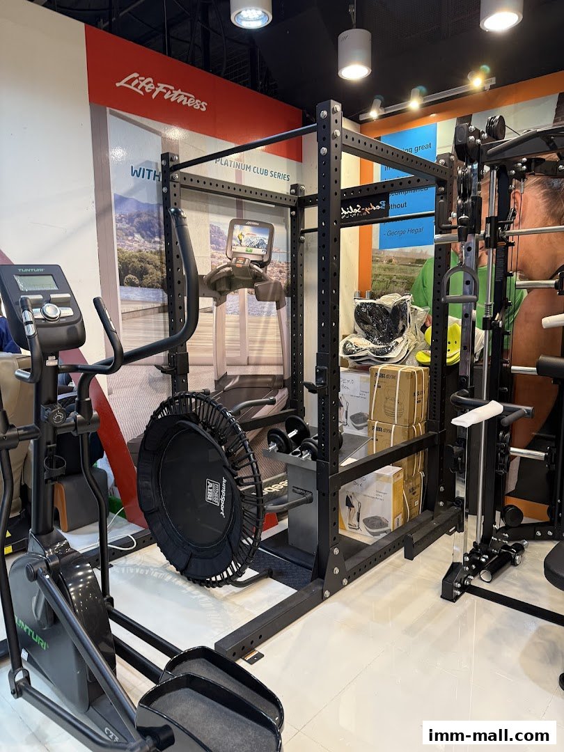AIBI shop interior showcasing various fitness equipment including an elliptical, a power rack, and a trampoline.