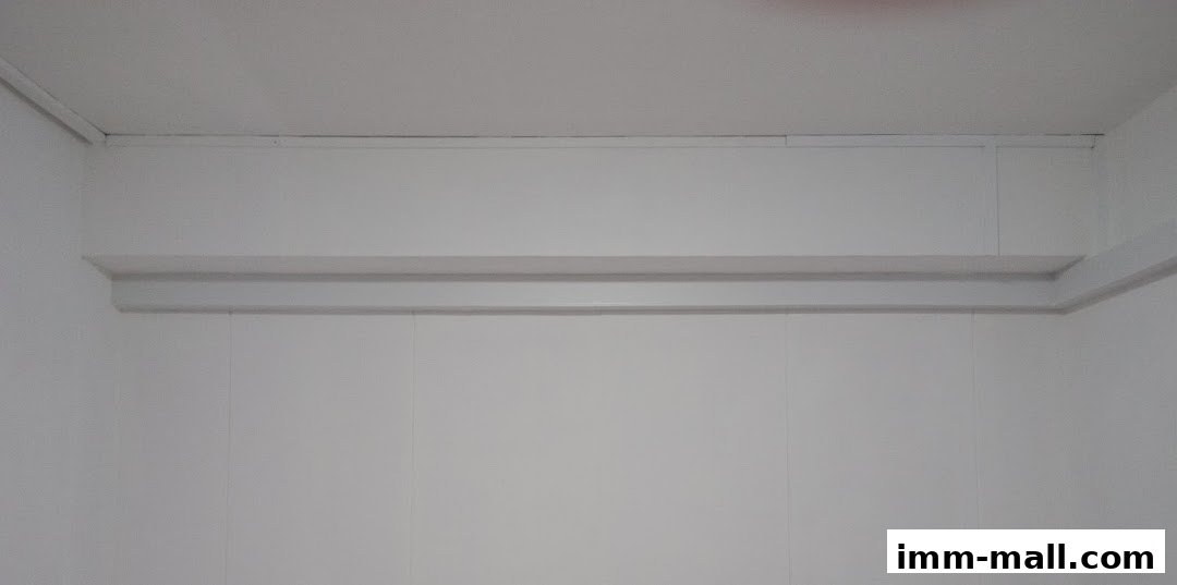 A clean, white wall with a decorative shelf and molding.