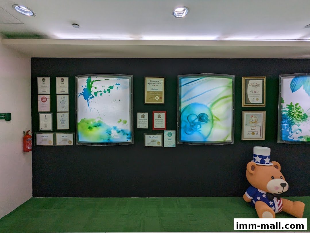 A wall display with awards, illuminated art, and a teddy bear in patriotic attire.
