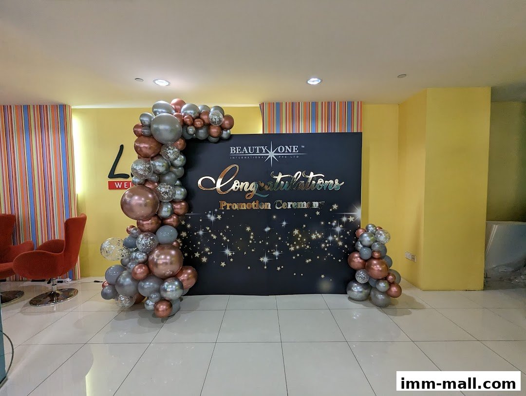 A promotion ceremony backdrop with balloons and the company logo.