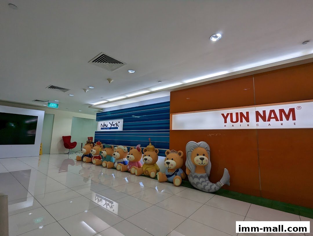 A row of teddy bear mascots and a mermaid plush toy are displayed in front of a Yun Nam Hair Care sign.
