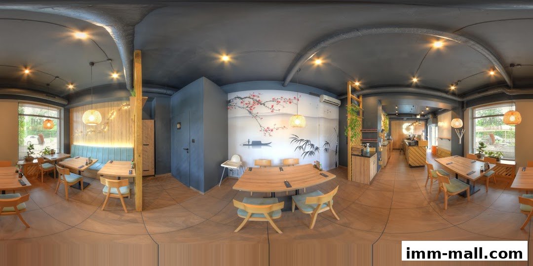Interior view of a modern restaurant with wooden tables, chairs, and Asian-inspired decor.
