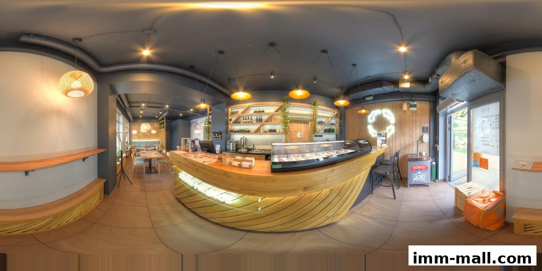 Interior view of a modern restaurant with a curved wooden counter and seating area.