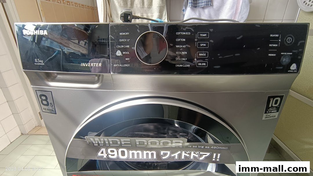 A silver Toshiba washing machine with a wide door and various wash cycle options displayed.