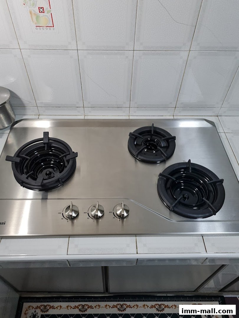 A stainless steel gas stove with three burners and control knobs.