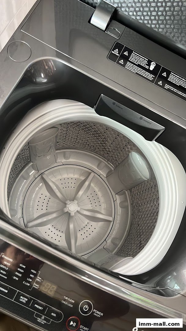 Interior view of a modern top-loading washing machine with control panel.