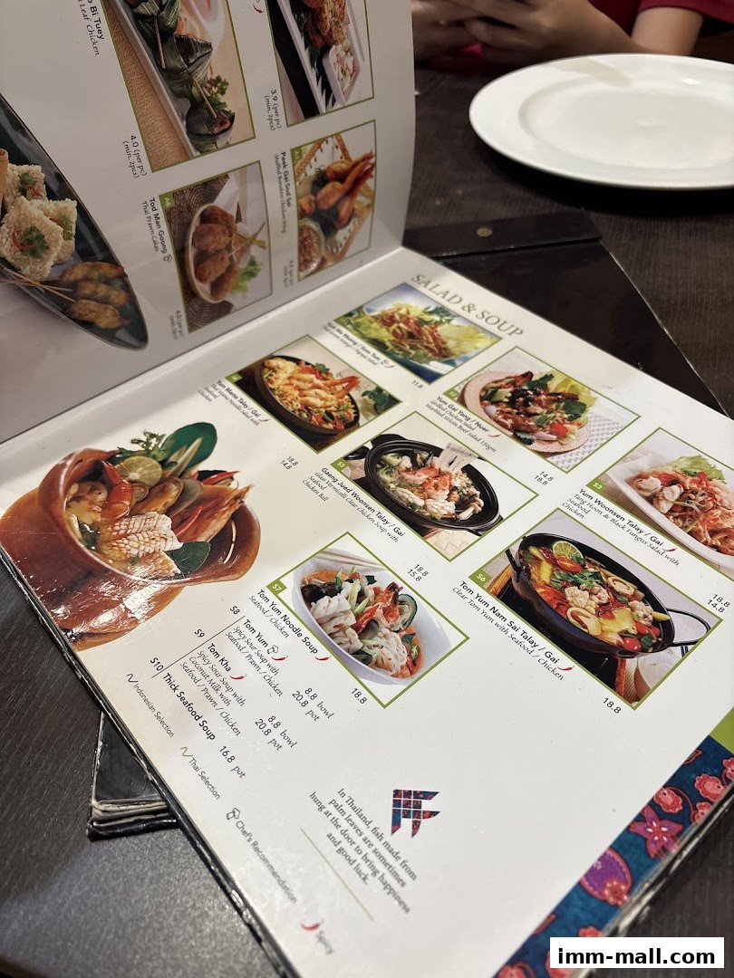 A close-up view of a Thai restaurant menu featuring various dishes and their descriptions.
