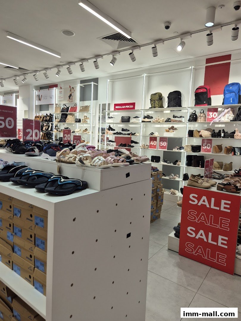 Interior view of a Bata shoe store with various footwear and bags displayed on shelves.