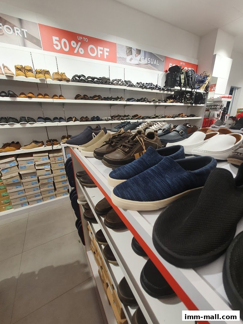 Interior view of a Bata shoe store showcasing various men's footwear and a "Up to 50% Off" sale.