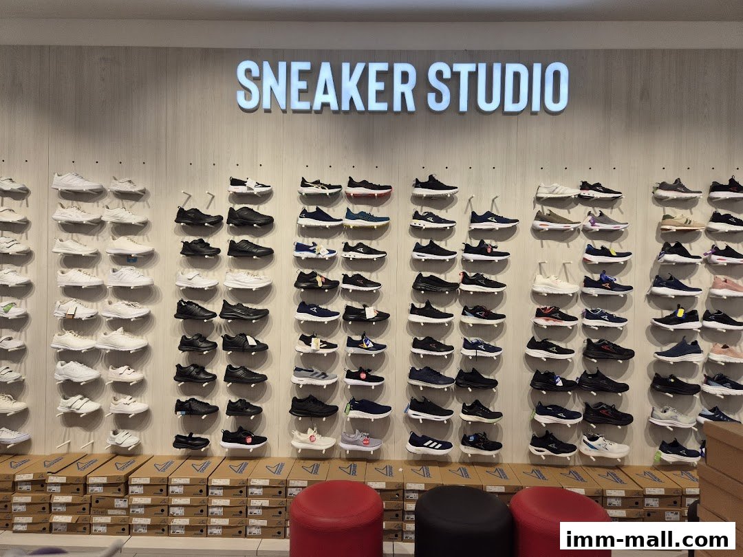 A wall display of various sneakers in a retail store, with boxes stacked below.
