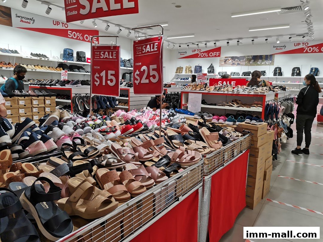 A Bata shoe store interior with a large selection of sandals and shoes on display, featuring sale signs.