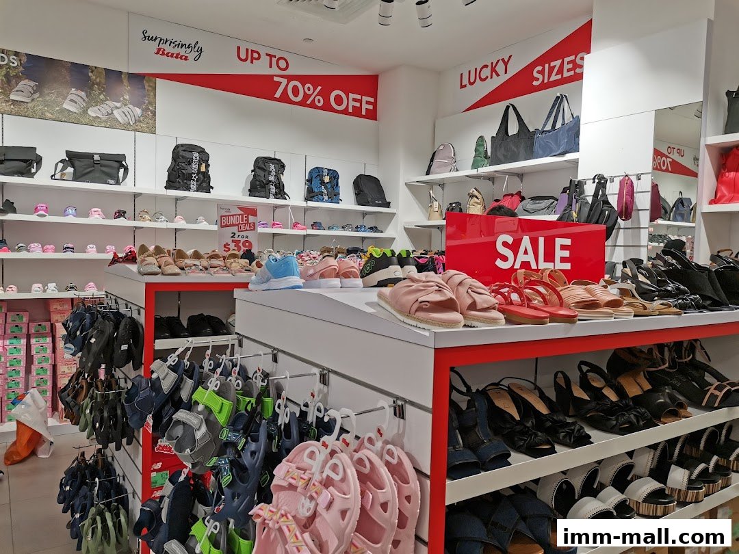 Interior view of a Bata shoe store with various footwear and bags on display, featuring a sale.
