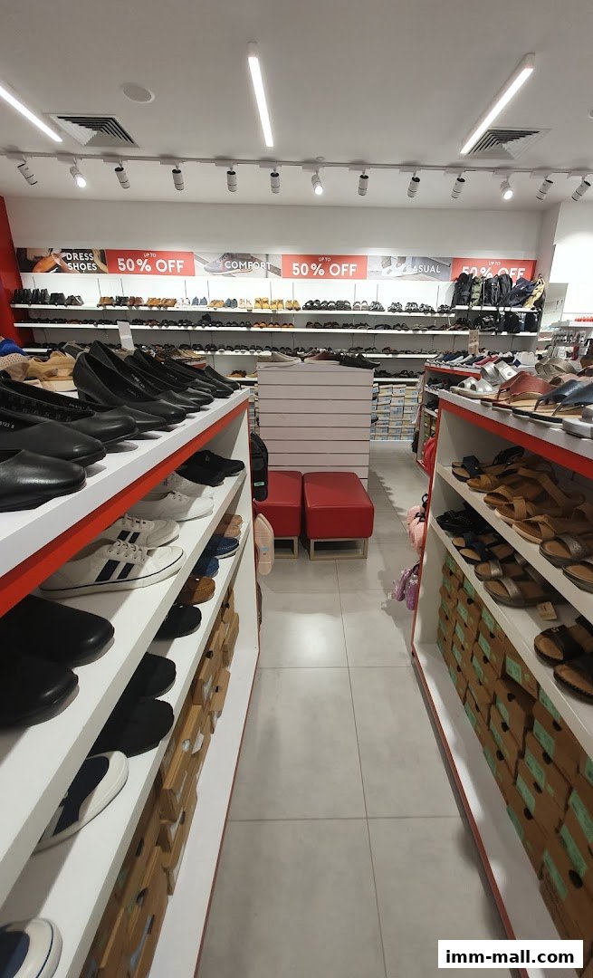 Interior view of a Bata shoe store with shelves full of shoes and sale signs.