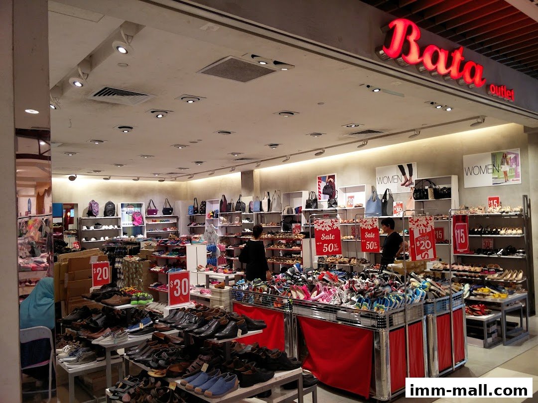 Interior view of a Bata shoe store with various footwear and bags on display, featuring sale signs.
