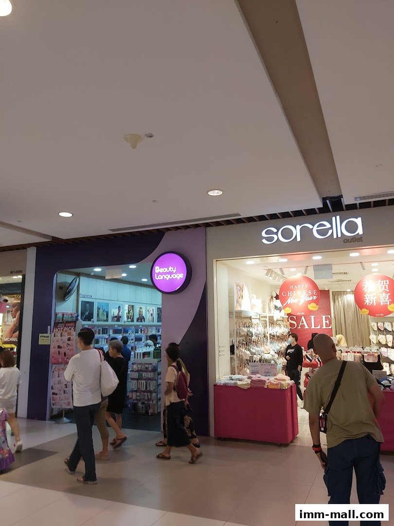 People walking past the Beauty Language and Sorella shops in a mall.