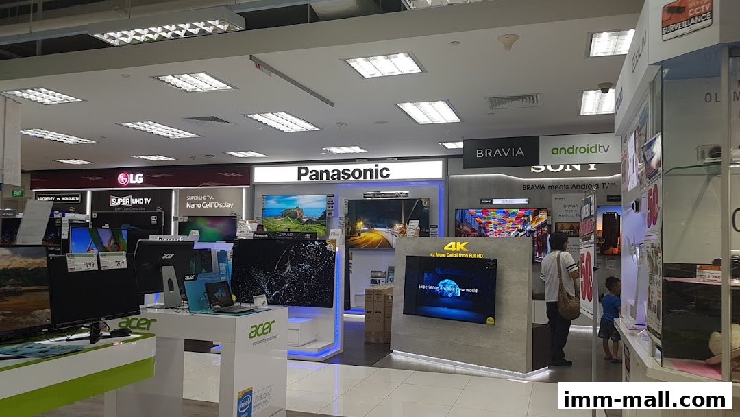 Interior view of an electronics store showcasing various televisions and laptops from brands like LG, Panasonic, and Sony.