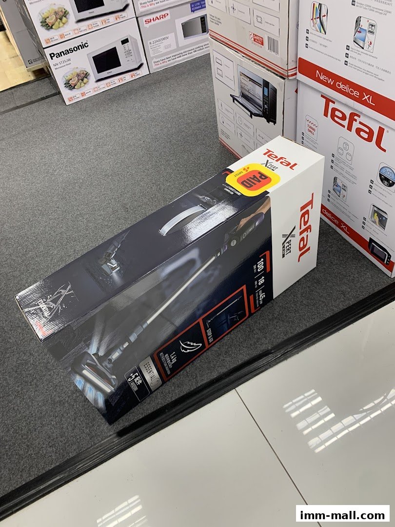 A box for a Tefal vacuum cleaner is displayed in front of stacked boxes of microwaves.