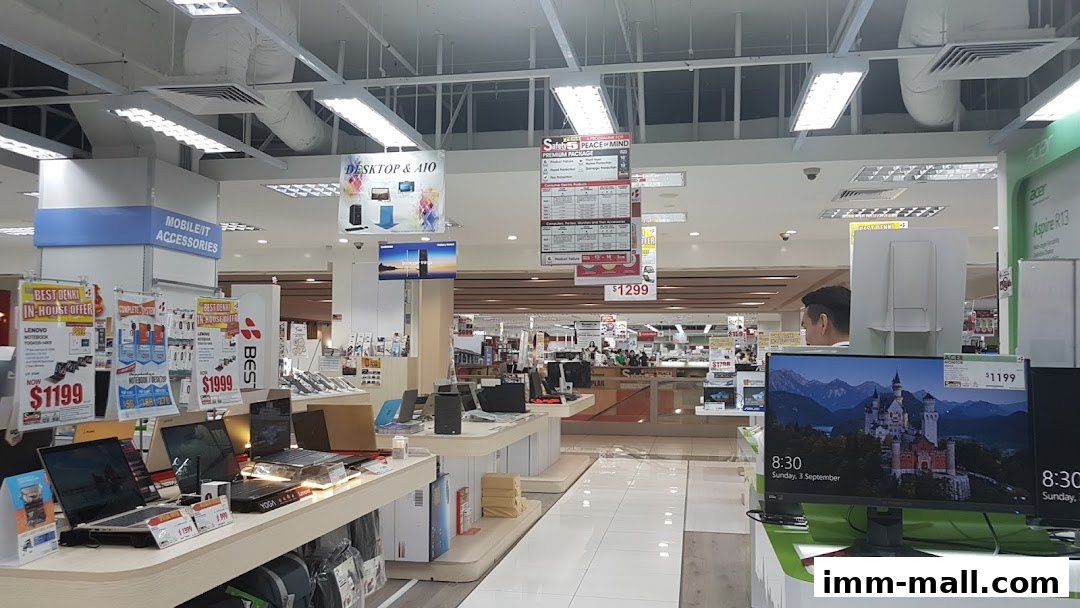 Interior view of a Best Denki electronics store showcasing laptops, monitors, and accessories with promotional signage.