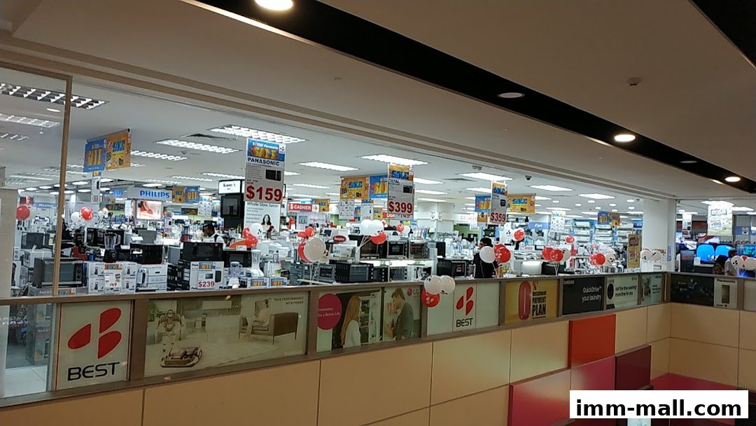 Interior view of a Best Denki electronics store with various appliances and sale signs.