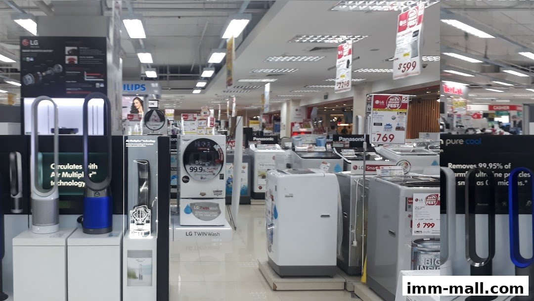 Interior view of an electronics store showcasing various appliances like washing machines and air purifiers.