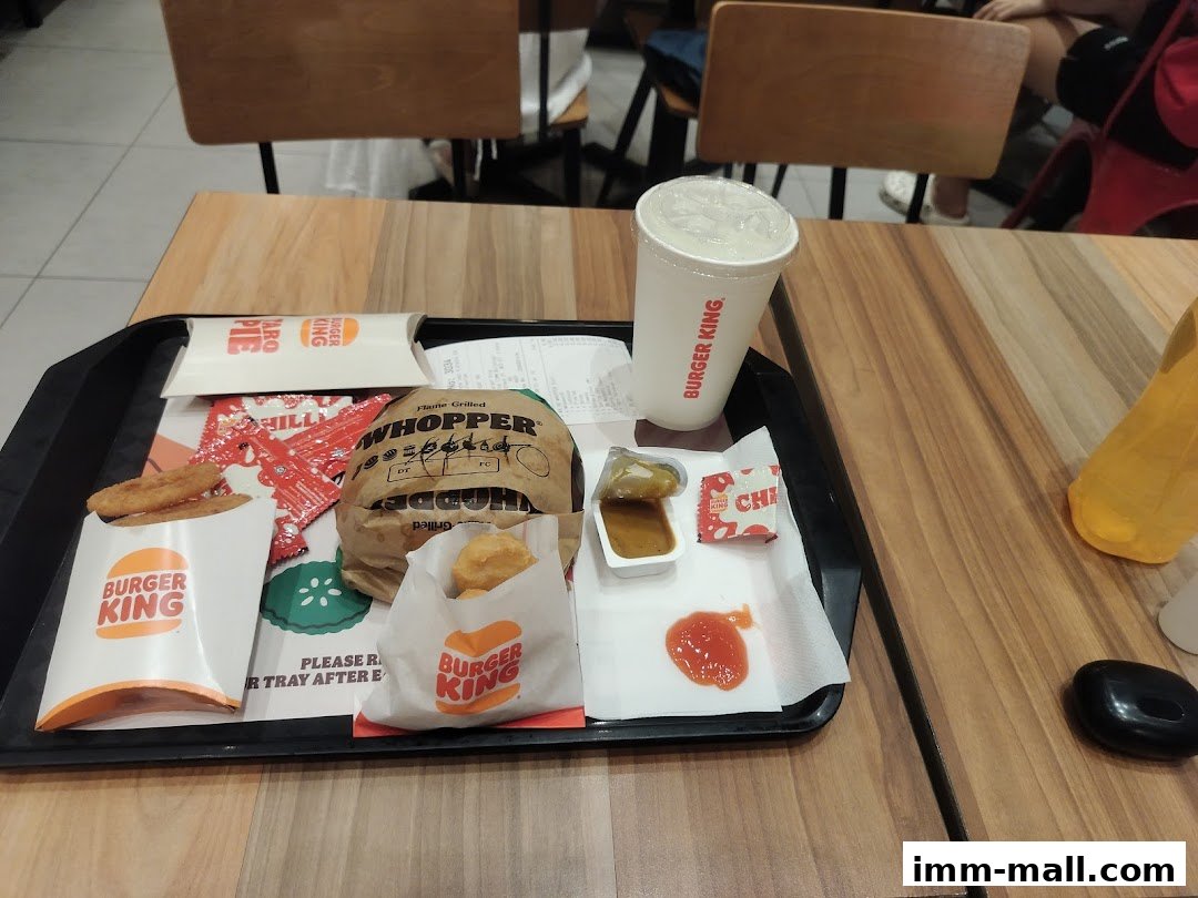 A Burger King meal on a tray, including a Whopper, fries, nuggets, drink, and sauces.