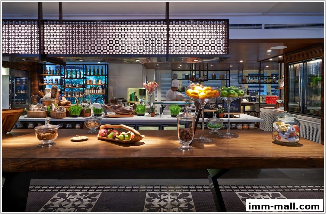A beautifully arranged food display counter with fresh fruits, bread, and pastries.