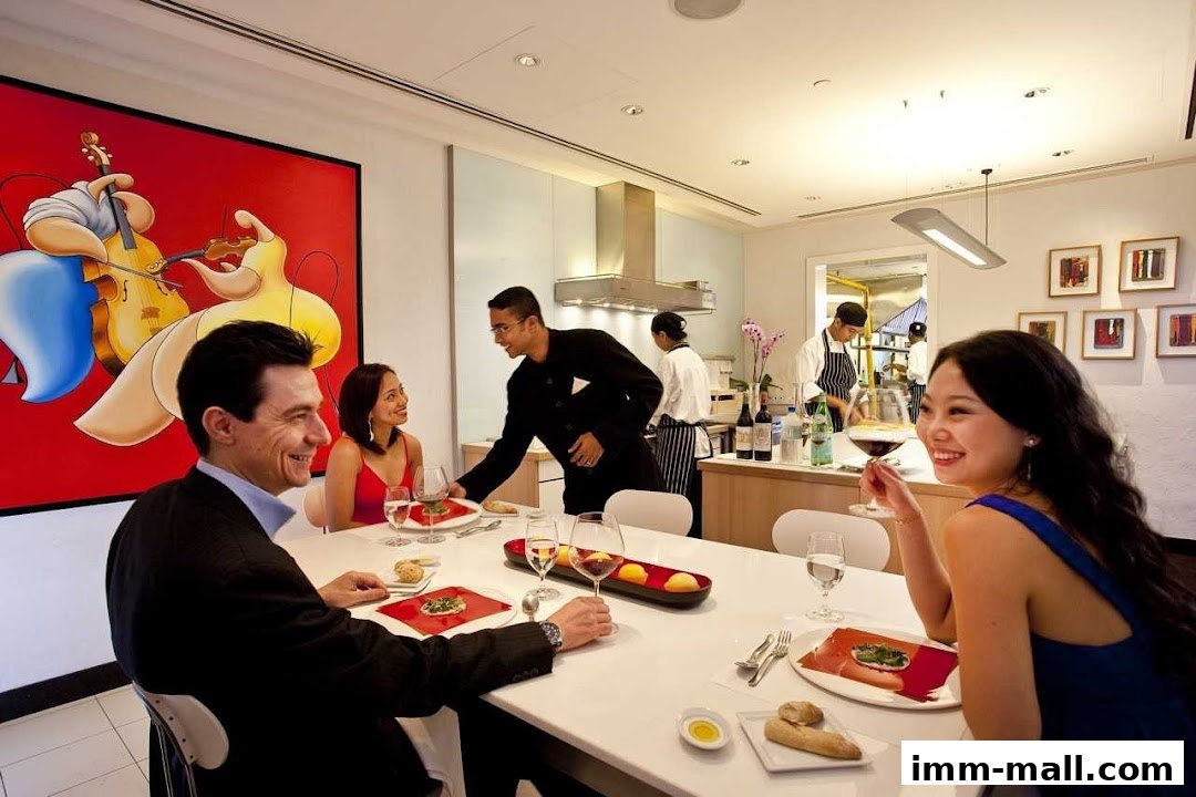 Diners enjoy a meal at a table while staff serve them in a modern restaurant setting.