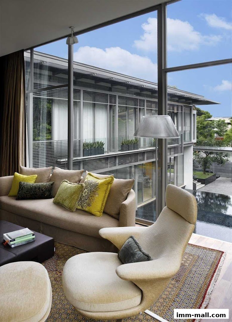 A modern living room with a large window overlooking a building and a pool.