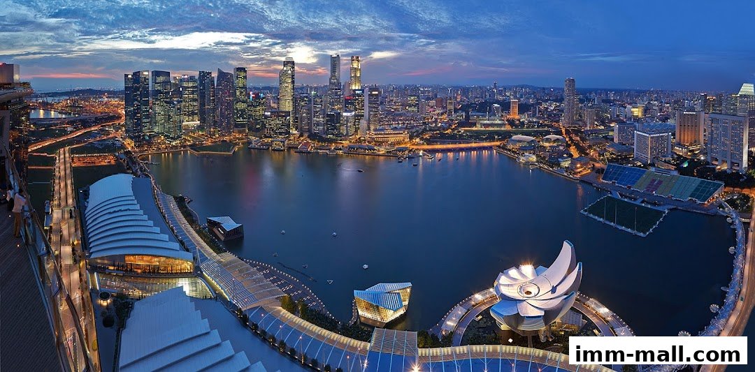 Panoramic view of a city skyline at dusk with a large body of water and modern architecture.