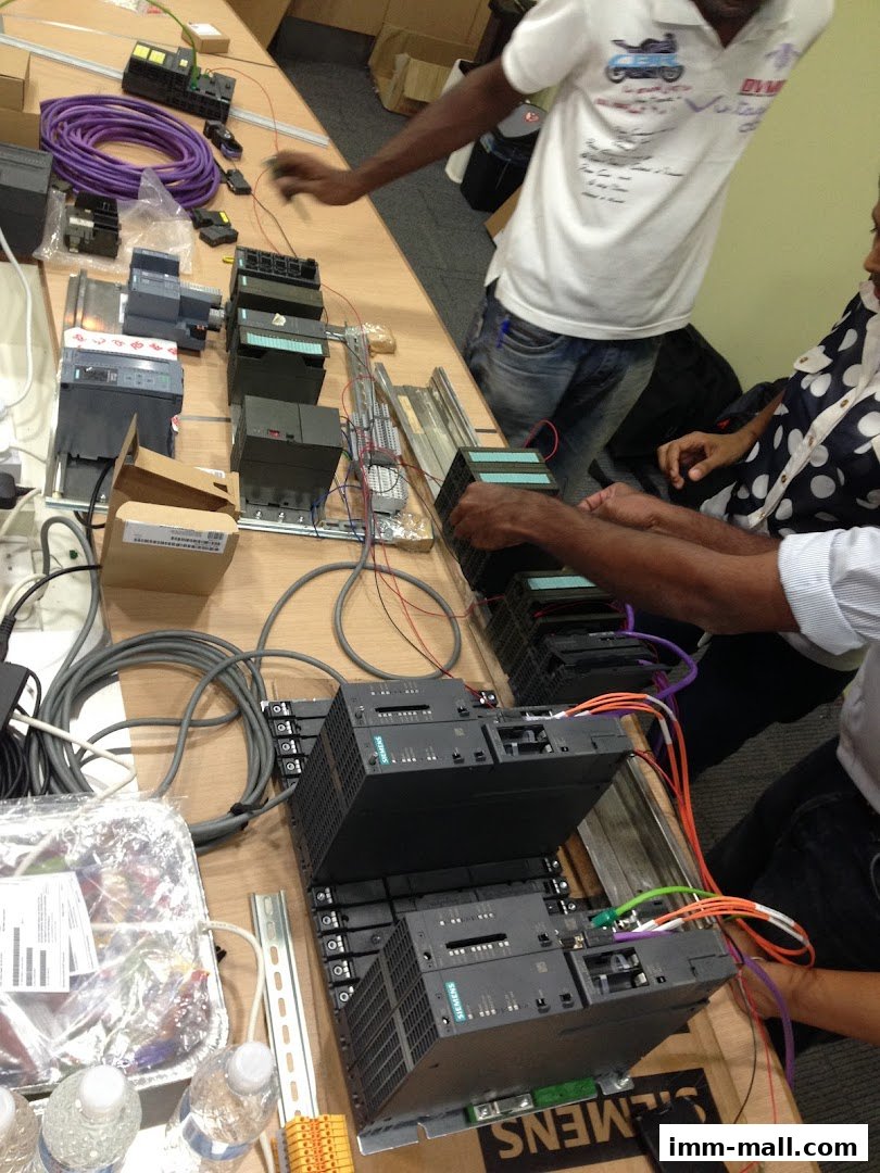 People working with industrial automation equipment and components on a table.