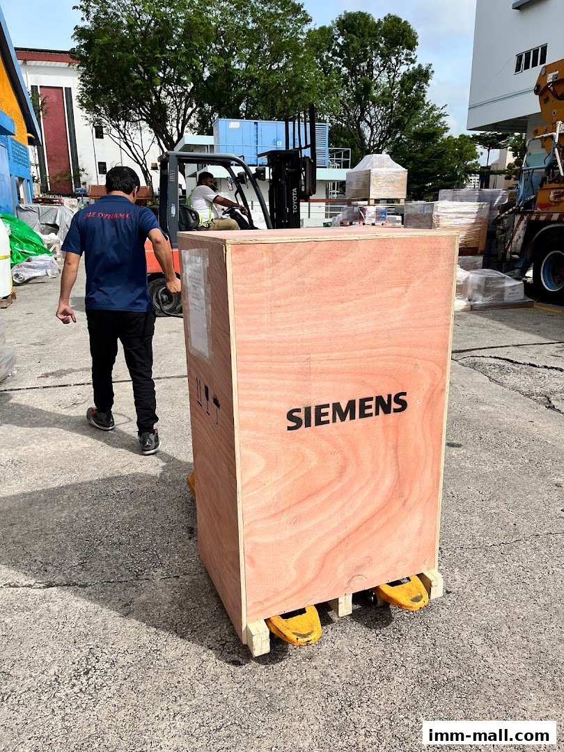 Workers move a large wooden crate labeled SIEMENS with a forklift and pallet jack.