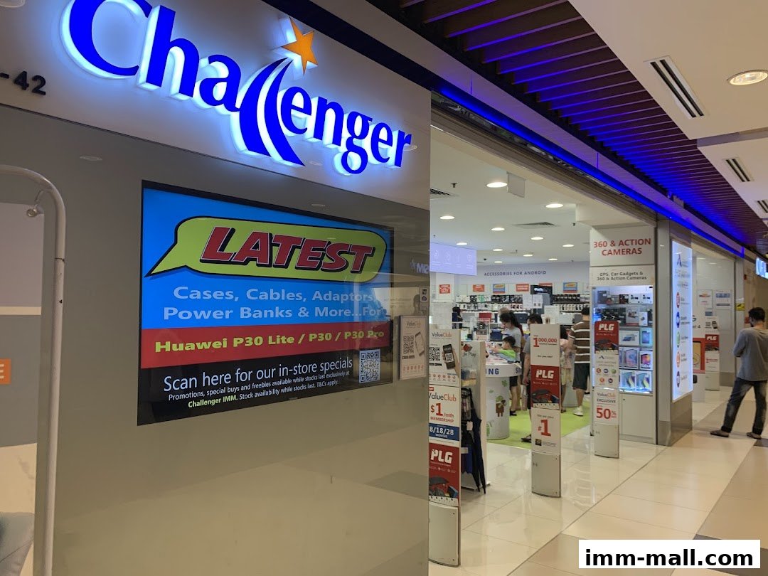 Challenger IMM electronics store entrance with a large illuminated sign and promotional displays.