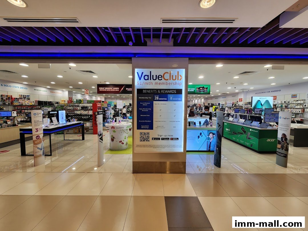 The entrance of Challenger IMM electronics store, showcasing various tech products and a membership promotion.