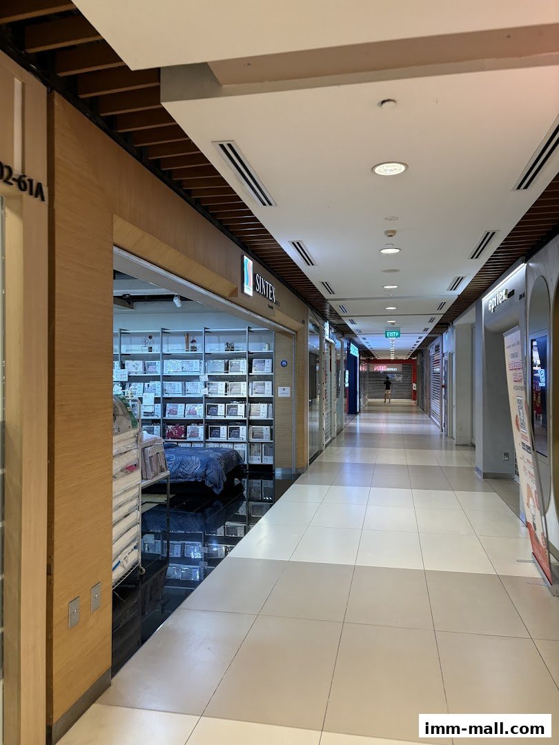 A view down a mall corridor with shops on either side, including a bedding store.