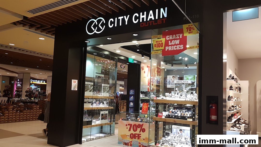 The City Chain Outlet store entrance, showcasing watches and promotional signage for low prices and discounts.