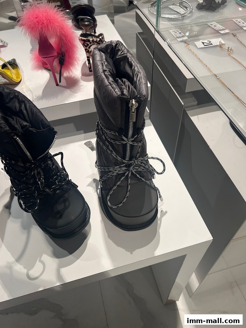 Stylish winter boots and fashionable heels displayed on white shelves in a retail store.