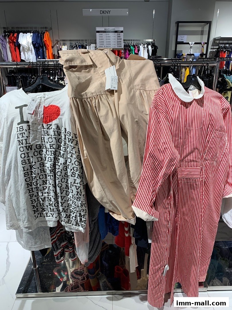 A display of fashionable clothing, including a graphic tee, beige pants, and a striped dress.