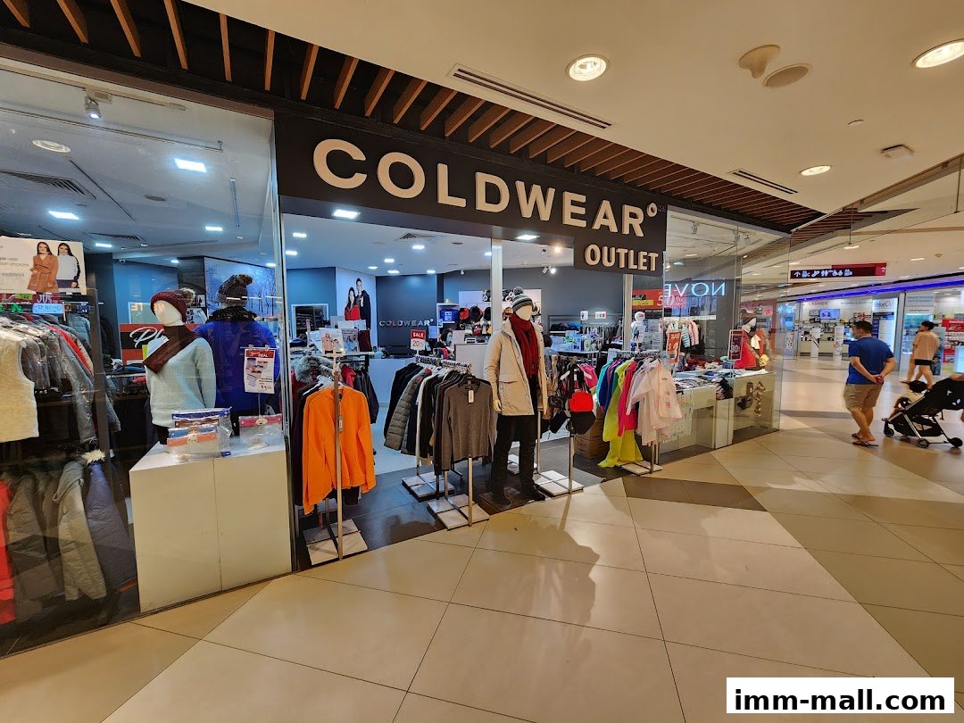 The entrance of a COLDWEAR OUTLET store displaying winter clothing on mannequins and racks.