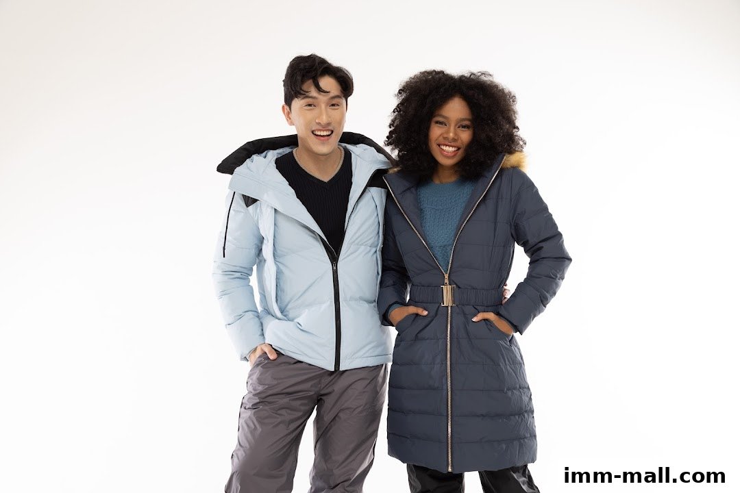 A smiling man and woman wearing stylish winter jackets and pants.