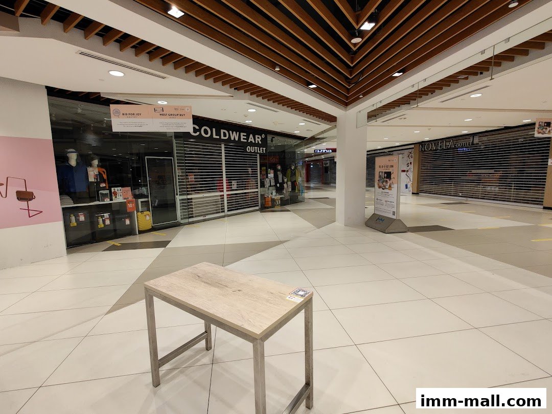 The COLDWEAR OUTLET shop front with closed shutters and mannequins visible inside.
