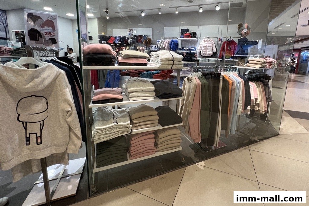 Interior view of a COLDWEAR IMM Outlet shop displaying folded and hung apparel.
