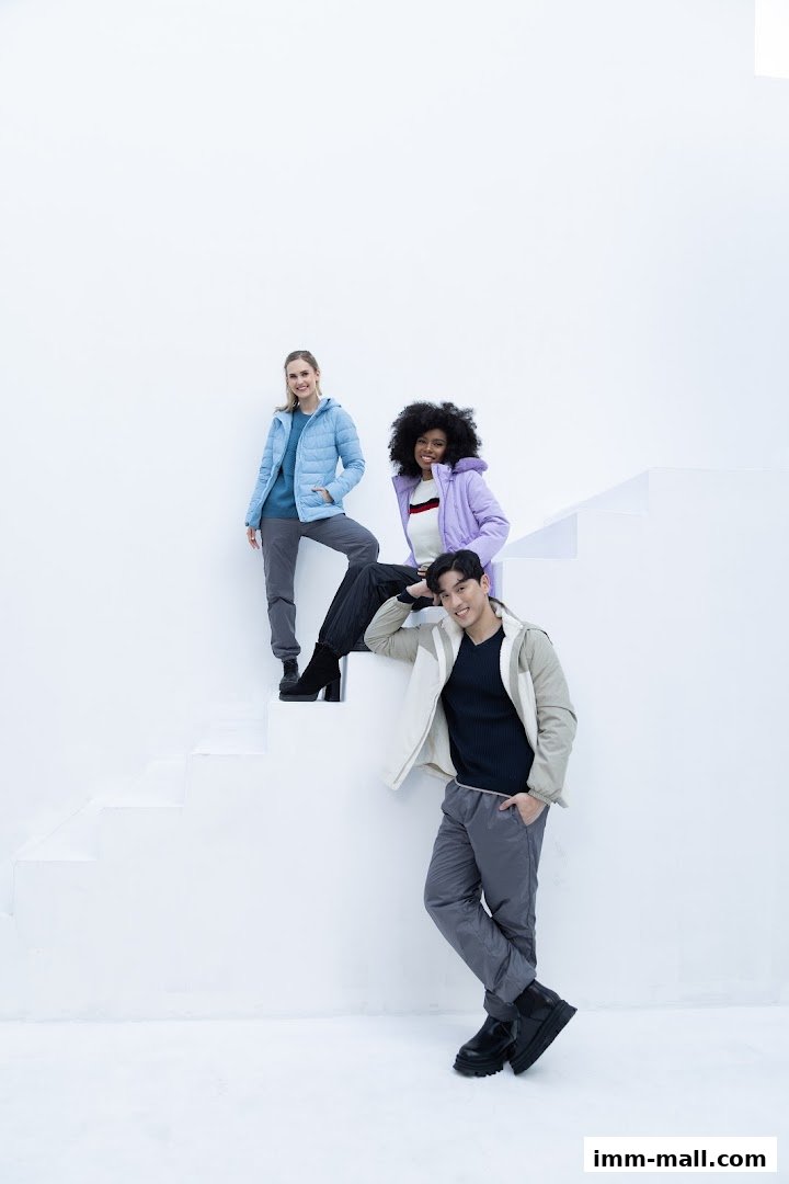 Three models posing on white stairs wearing stylish winter jackets and pants.