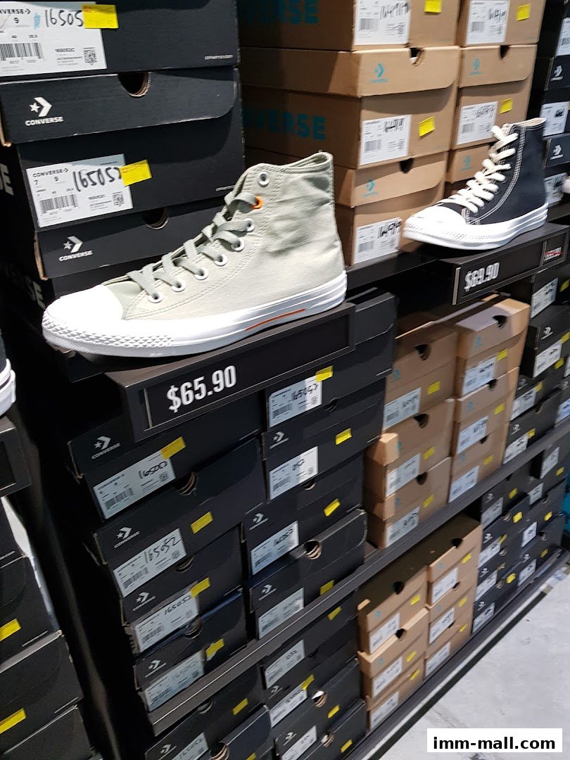 A display of Converse sneakers and their boxes on shelves in a retail store.