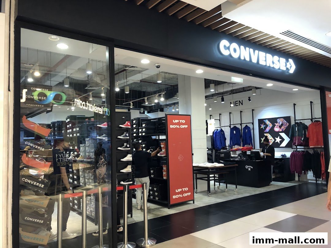 The exterior of a Converse store, showcasing shoes and apparel, with a prominent "Up to 50% Off" sign.